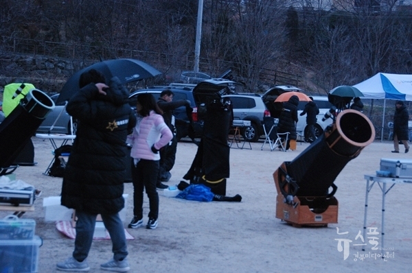 비가 내리자 천체망원경에 우산을 씌우거나 우의를 덮고 있는 참가자들