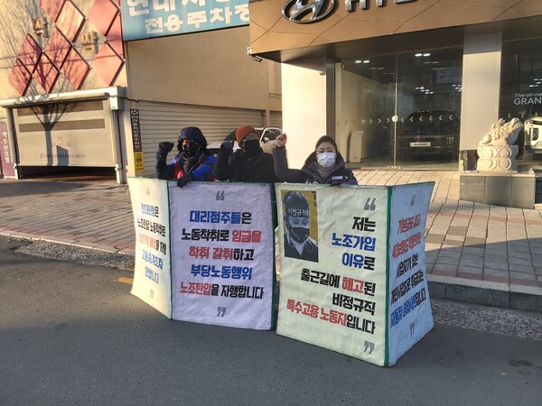 김경희 씨가 회사 앞에서 노동권 탄압에 항의하는 홍보 활동을 하고 있다.