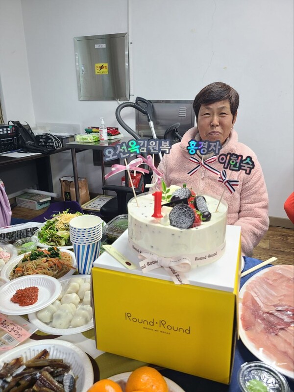 ▲돌잔치 주인공의 이름으로 케이크를 장식했다. 삼산1리 부녀회 회원분이 미소를 짓고 있다. 사진 내리리영주